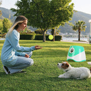 Happy Labrador retriever using ThePawtale automatic fetch machine in the backyard.